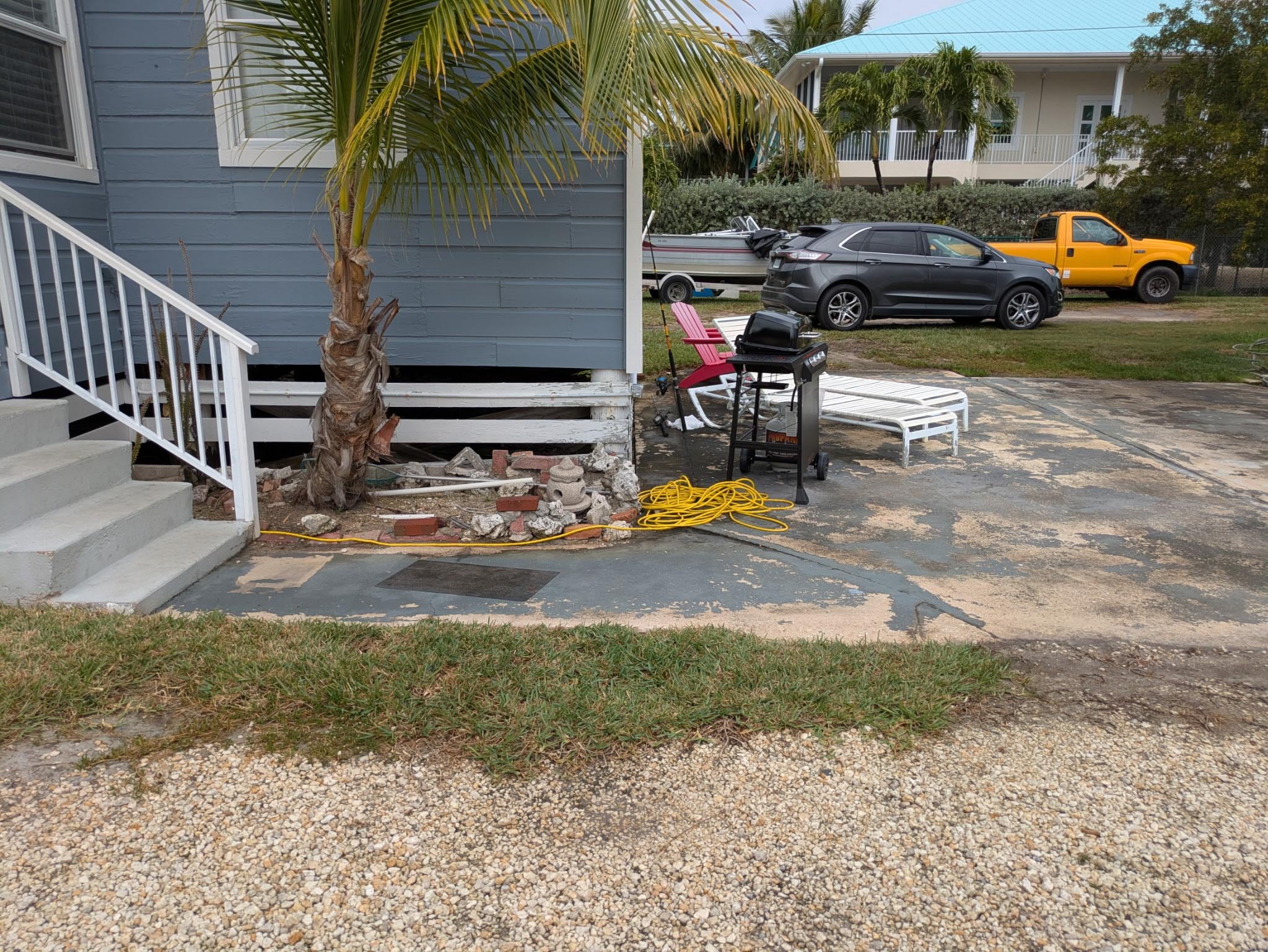 Entrance with patio slab with lounge chairs. 