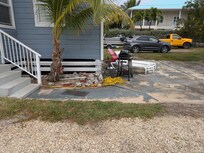 Entrance with patio slab with lounge chairs.