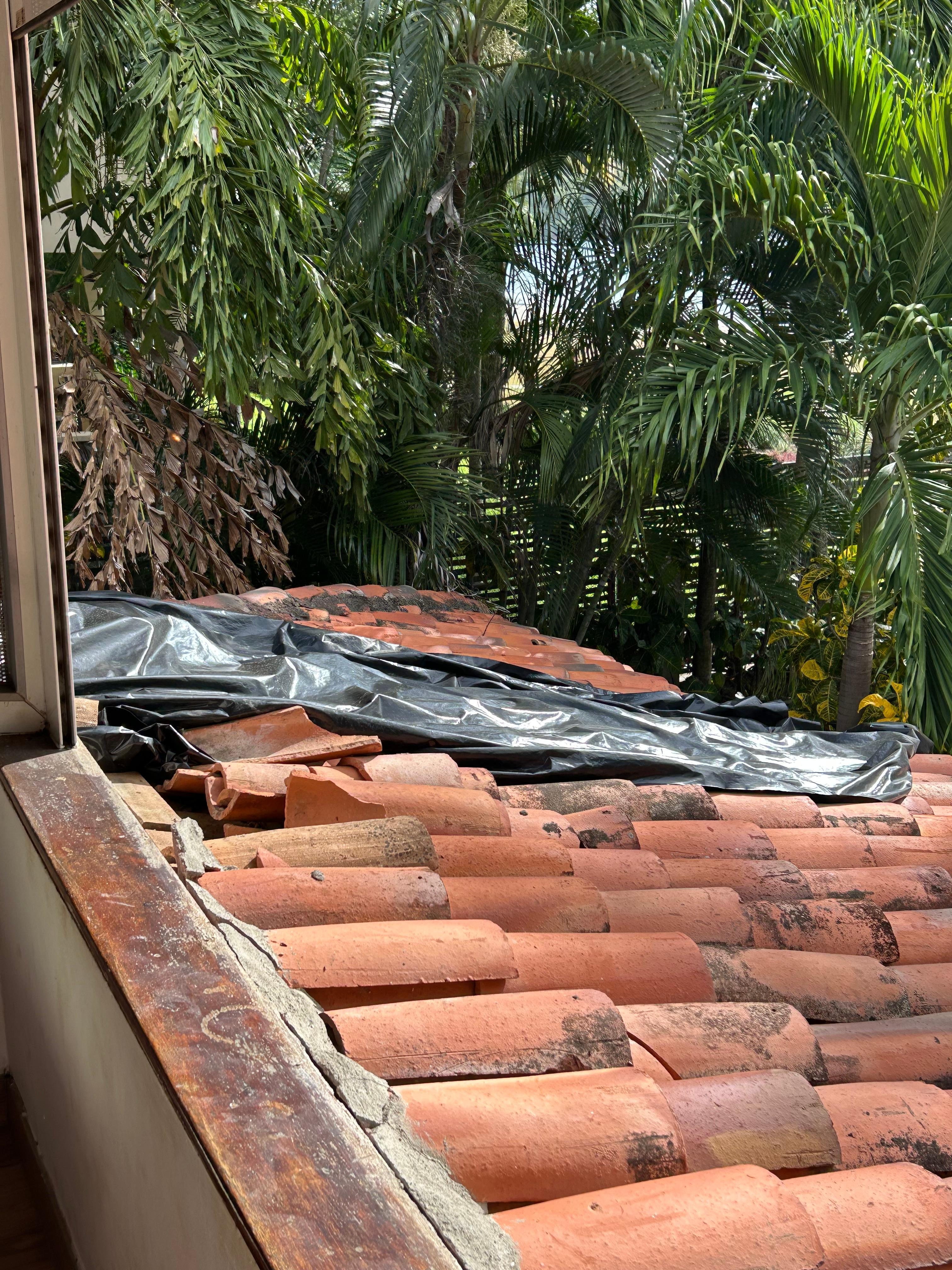 Broken roof tiles and tarpaulin above poolside bedroom
