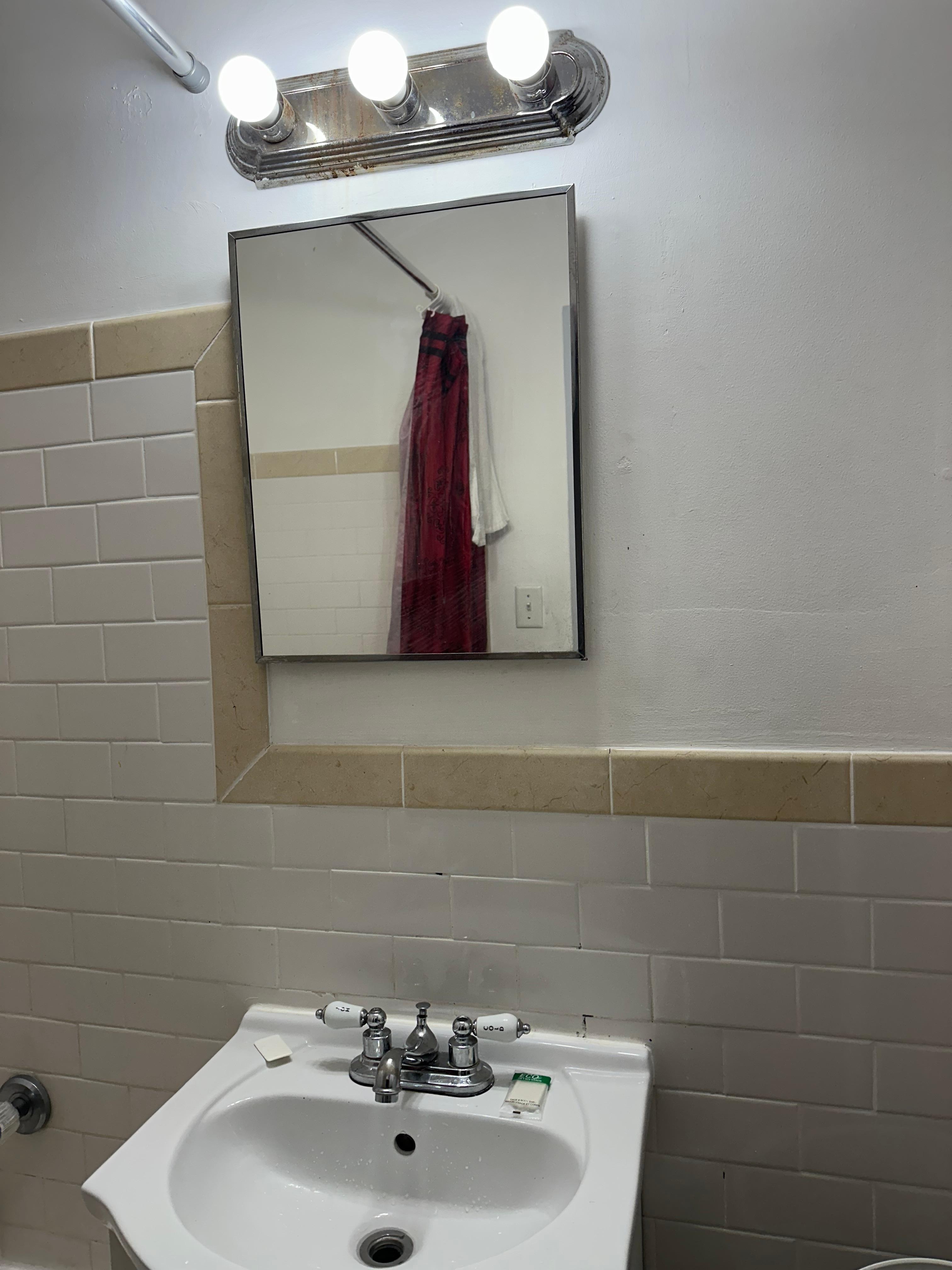 The mirror, light fixtures, and bathroom condition was dirty.