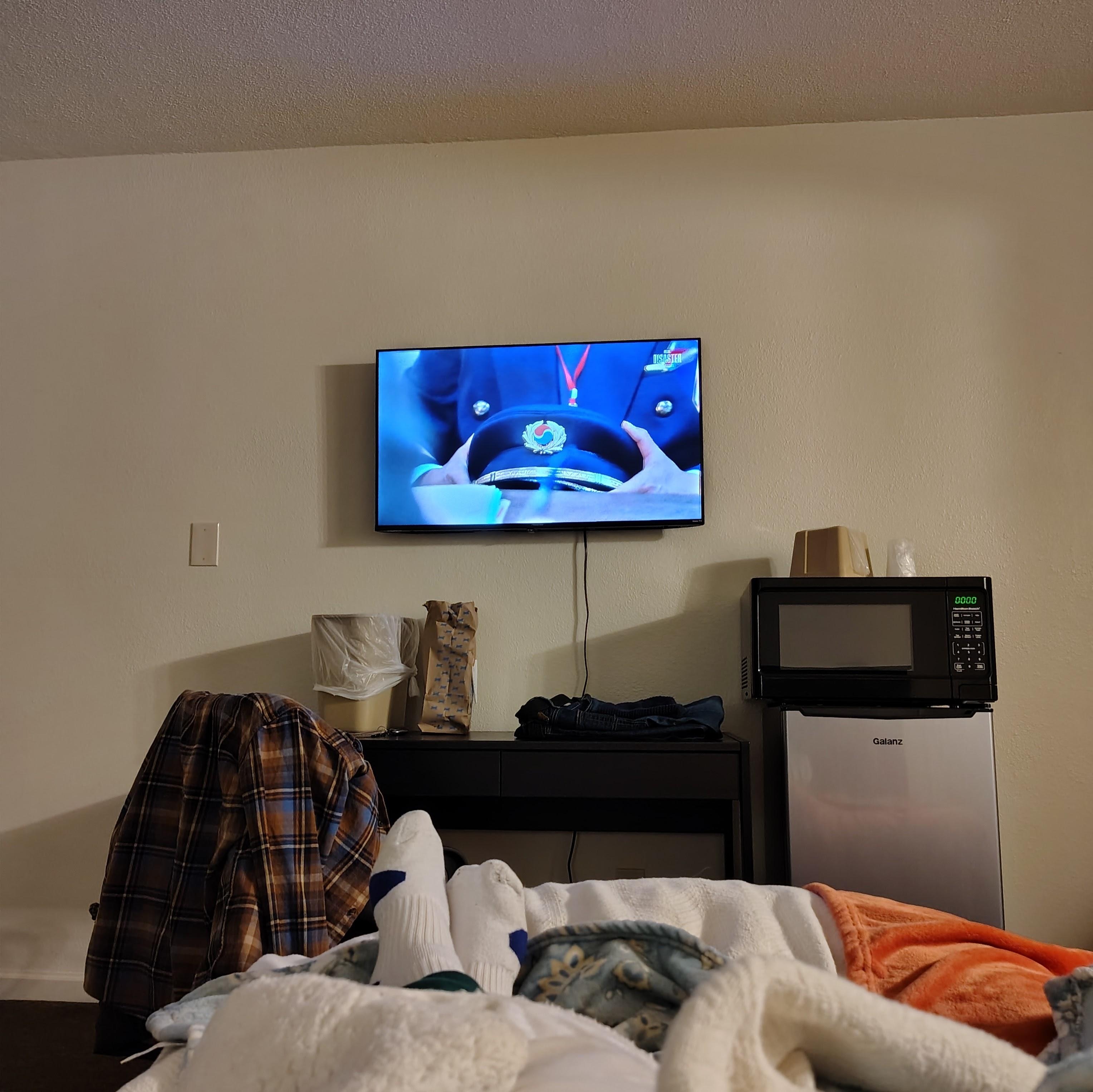 Single full bed with view of Roku TV