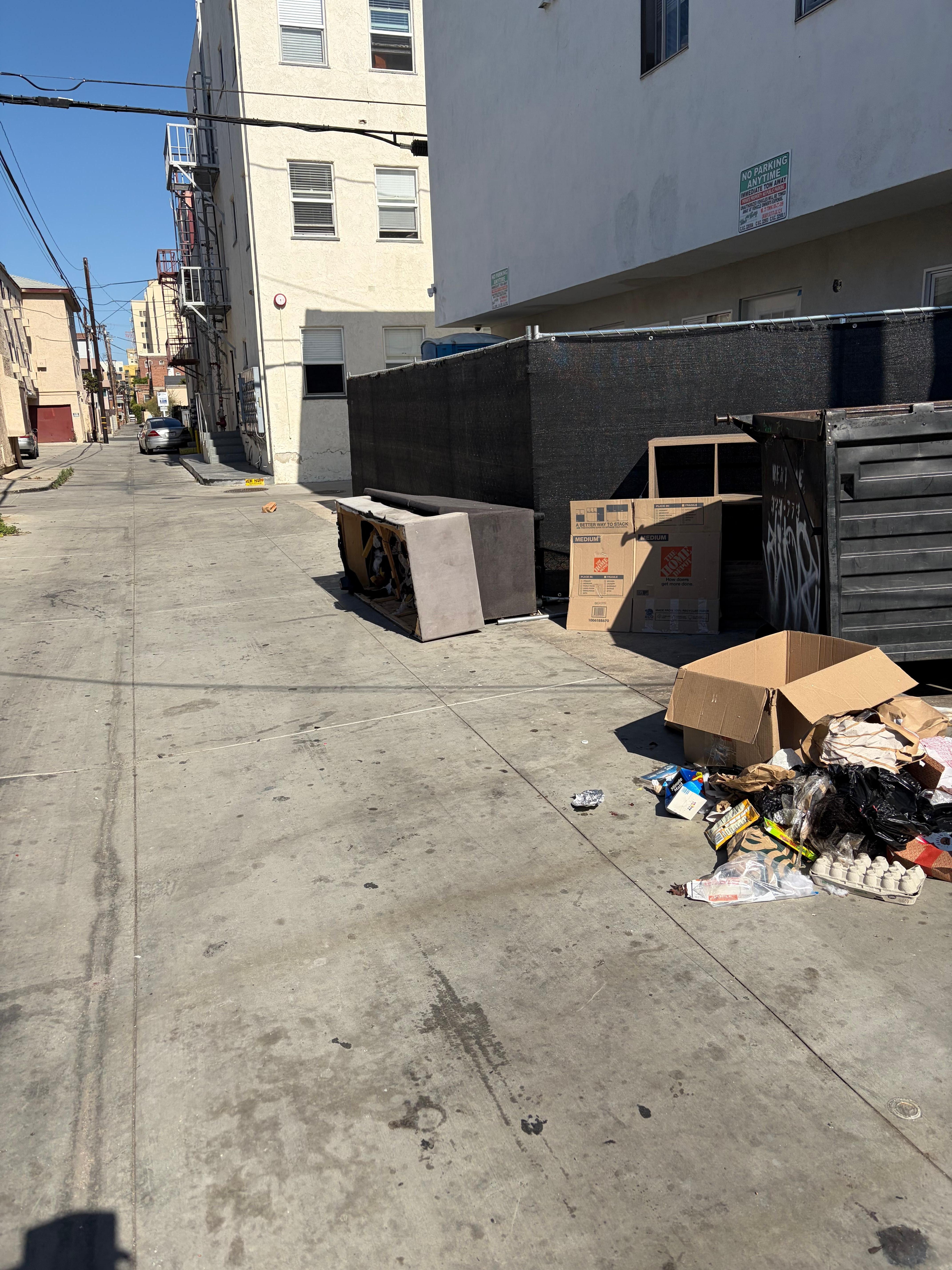 Garbage dumpster at parking entrance. 