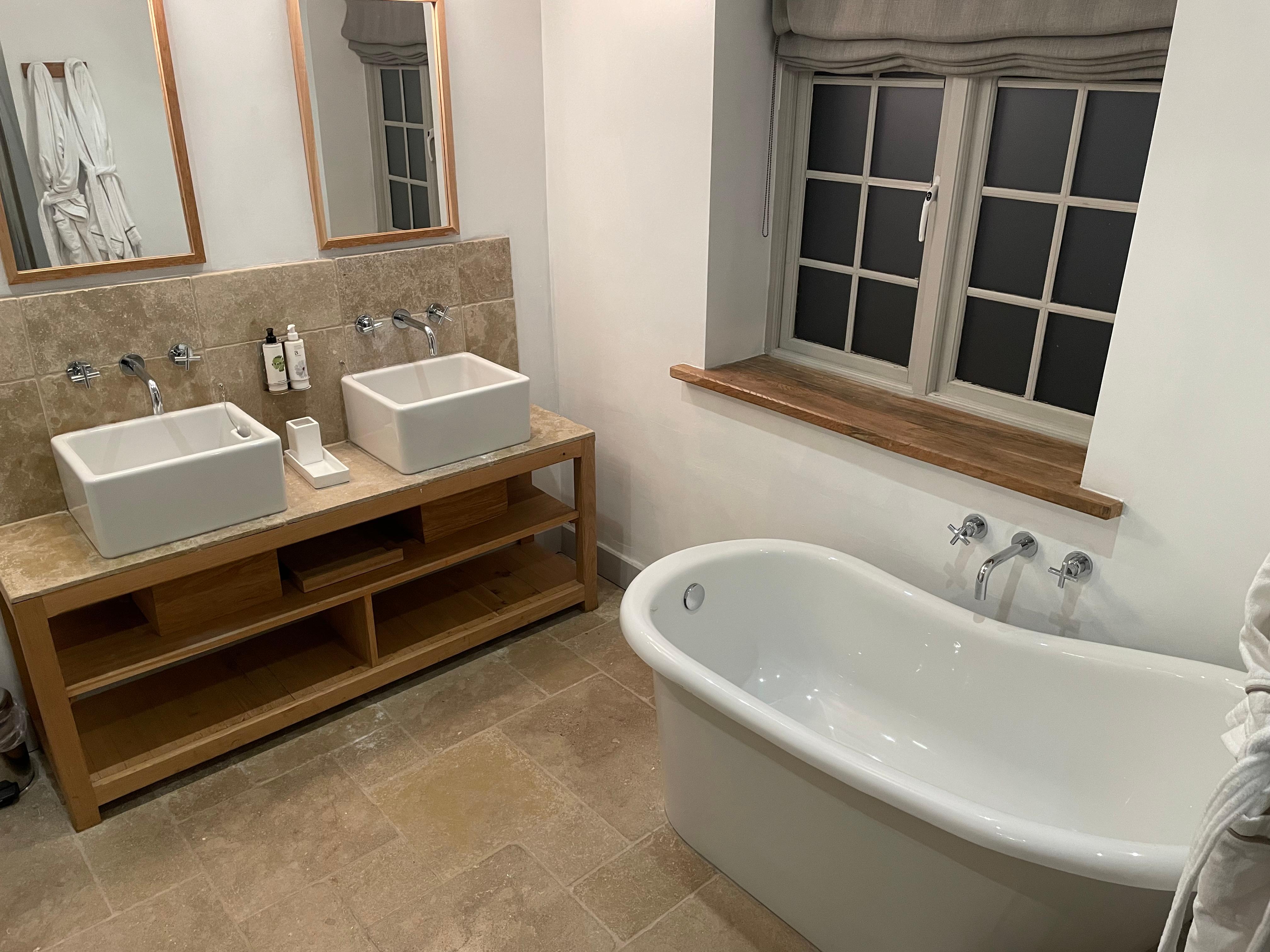 Beautiful bathroom with large shower and roll top bath, and large towels.