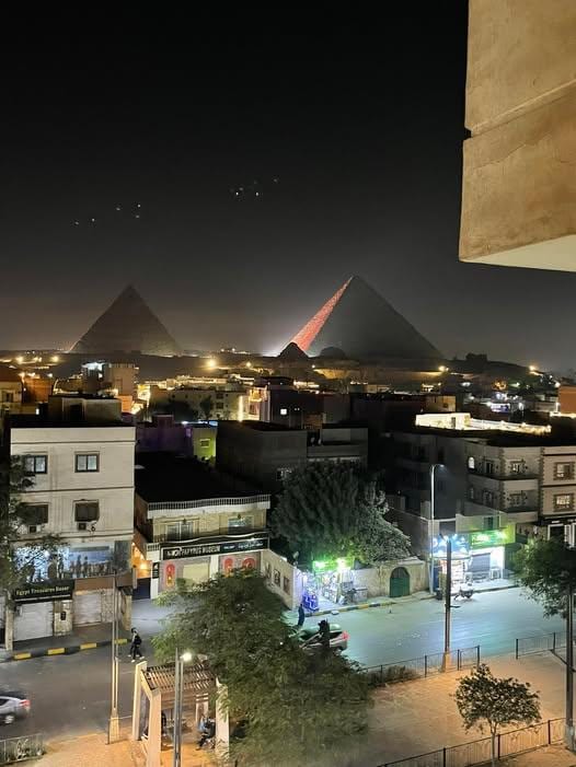 The view of the pyramids at night from my hotel room window at Horizon Pyramids View Inn