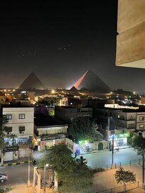 The view of the pyramids at night from my hotel room window at Horizon Pyramids View Inn