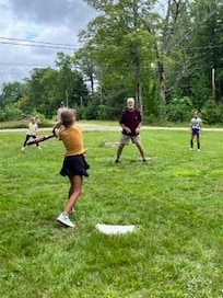 Wiffleball out front on newly mowed lawn.