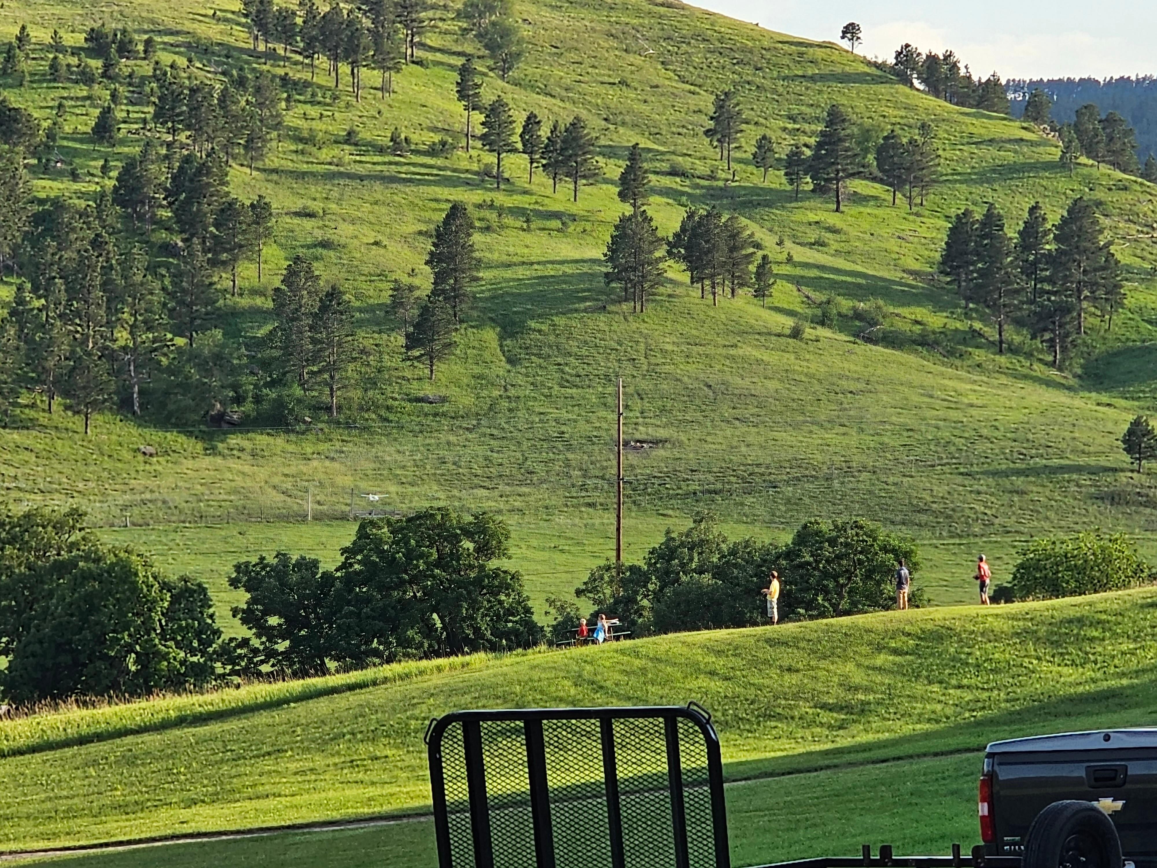 South view of the Valley. Kids flying remote control airplanes over the lawn