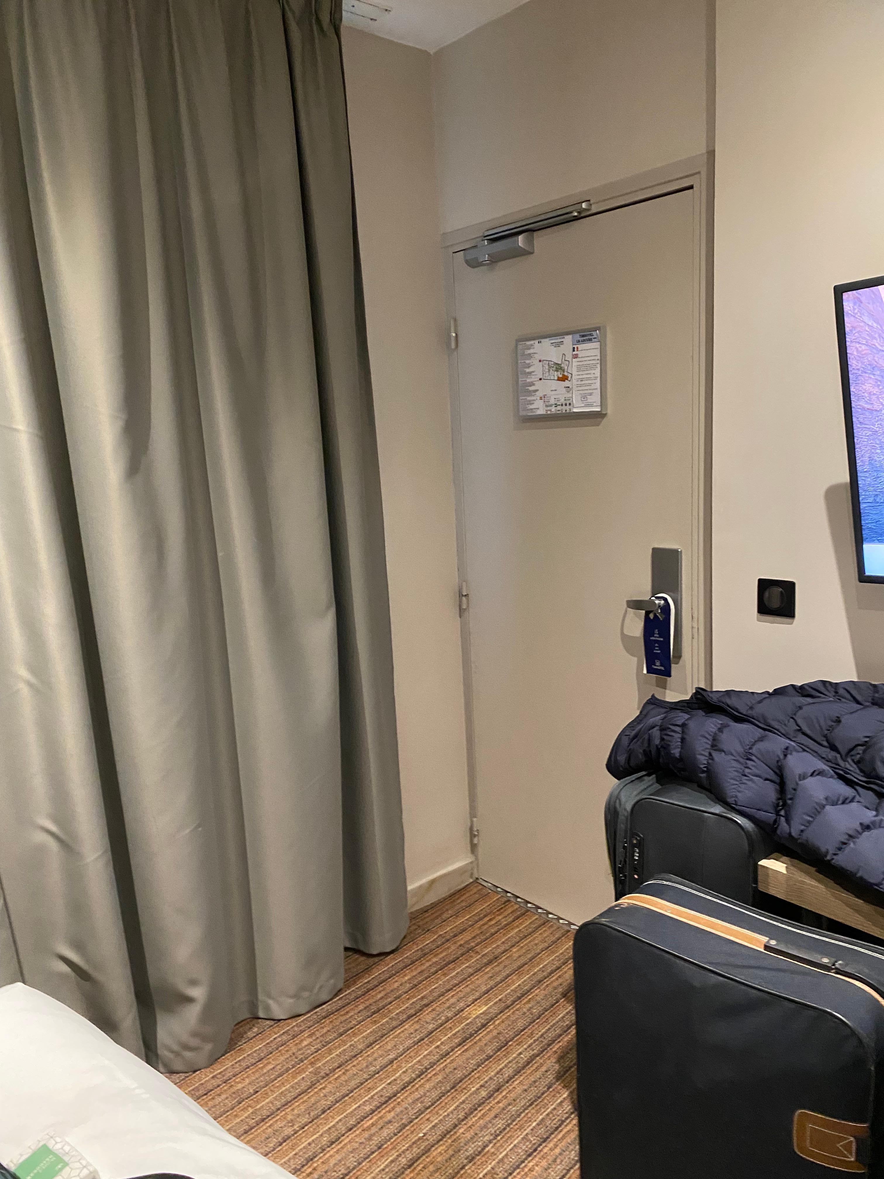 Beside the bed looking at the dooe