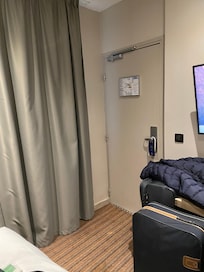 Beside the bed looking at the dooe