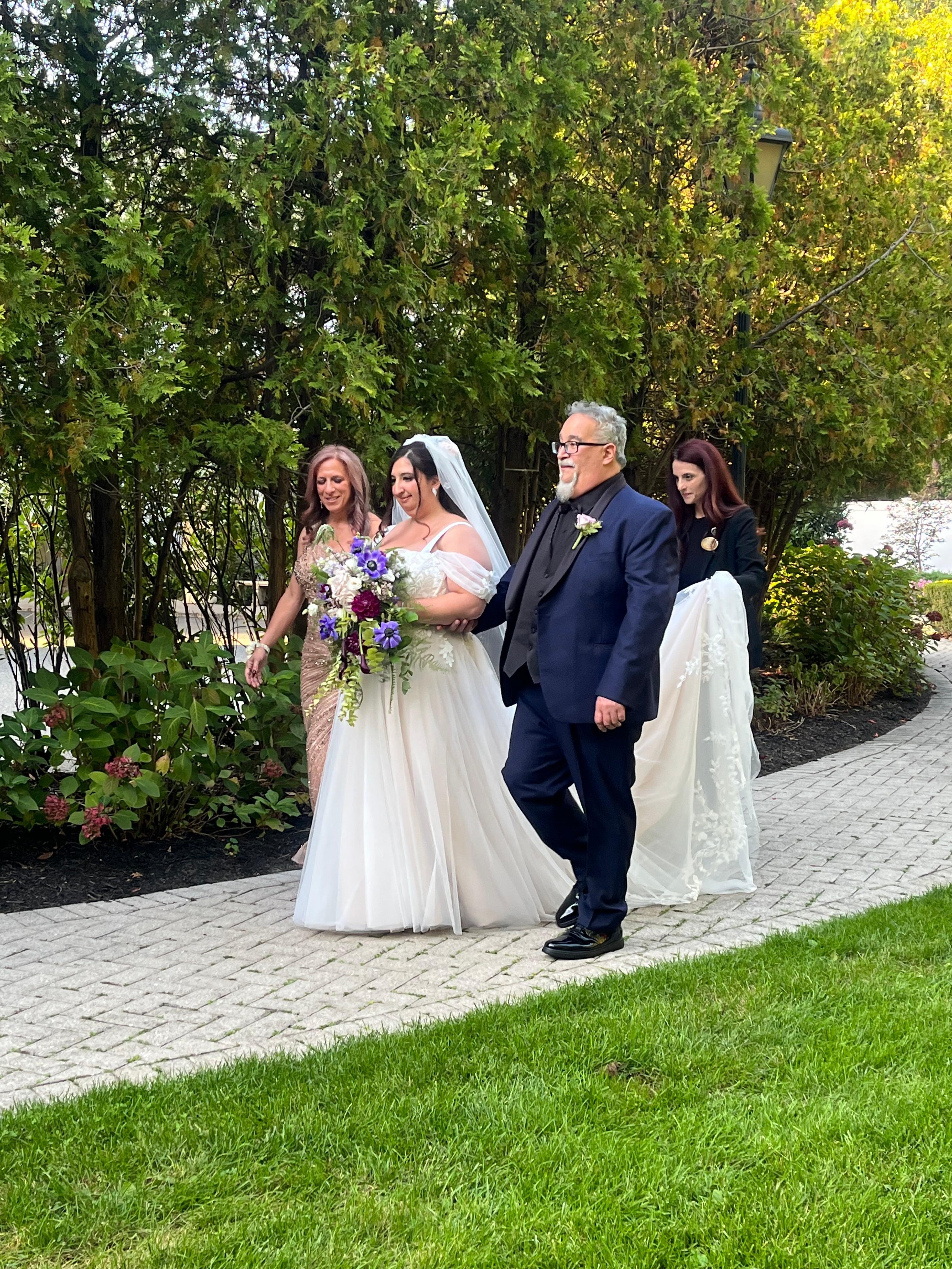 The bride being walked down the aisle to the lovely gazebo where the ceremony took place.