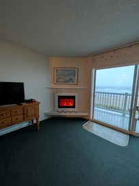 Living room with pull out sofa, TV, fireplace and sliding door to deck. It was hard to use the deck as the water from the floor above. You kept dripping down on you. No privacy barrier between the decks either