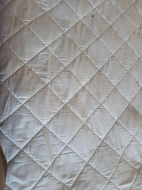 Mattress and sheets dirty with hair and stains on sheet and mattress