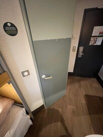 Here is their attempt at fixing the door. You can see the discoloration where they put wallpaper over the hole.