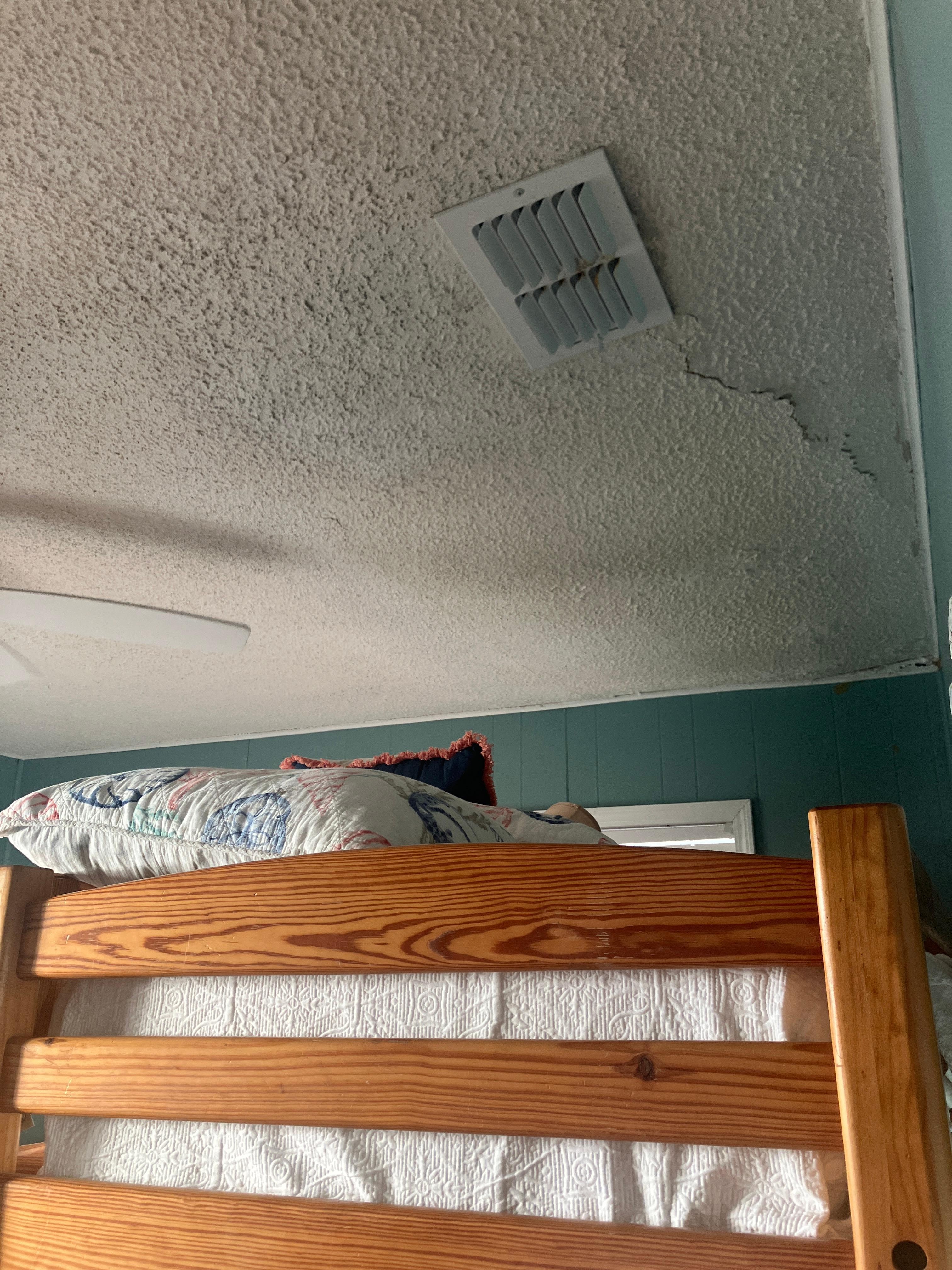 Buckled ceiling and the ceiling fan extends into bunk area.