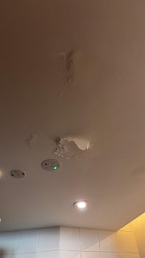 The peeling paint in the bathroom ceiling