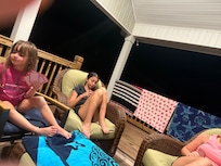 Family playing cards on the front deck.