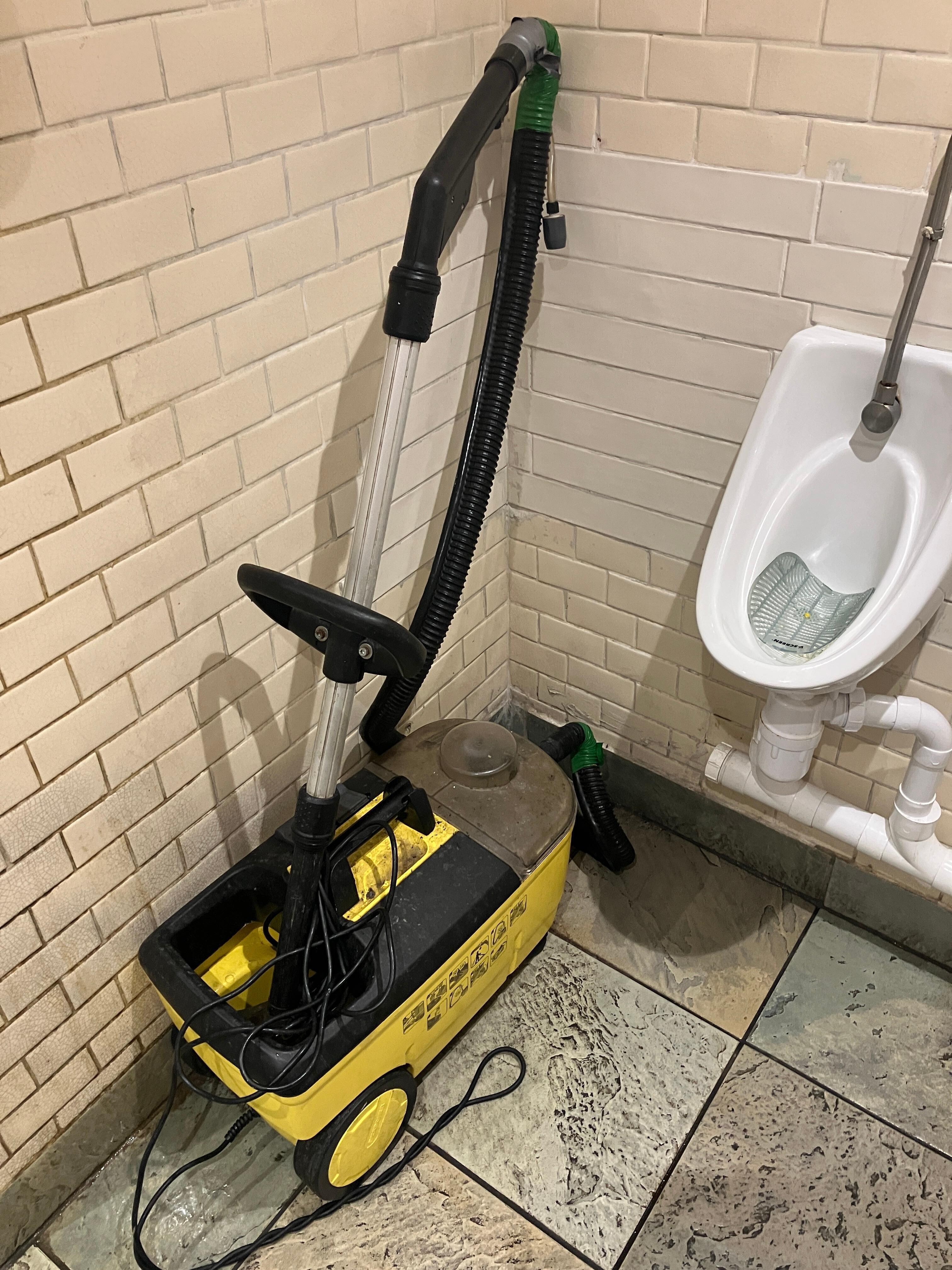 Vacuum cleaner left in gents toilets by urinal