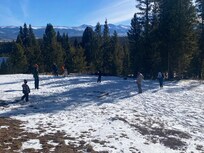 Family playing wiffle ball in the snowy yard