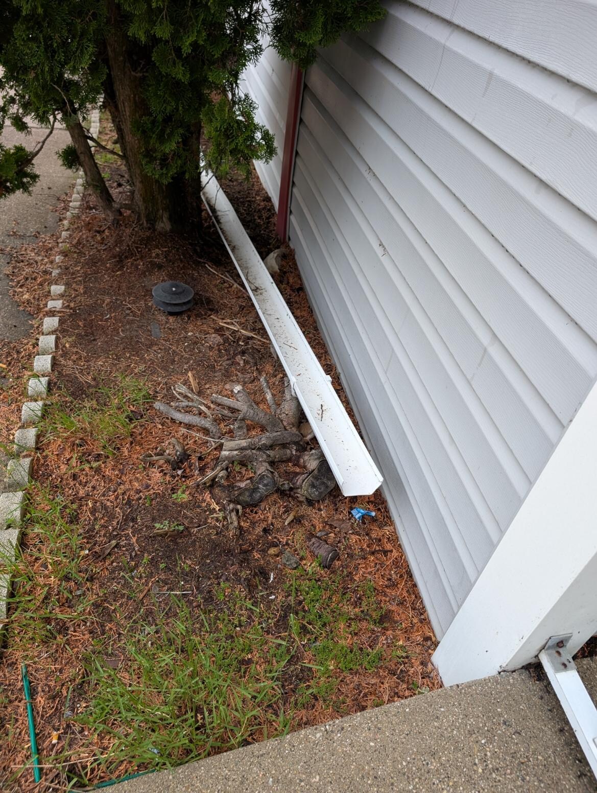 3 sections of roof gutter fallen into the landscaping