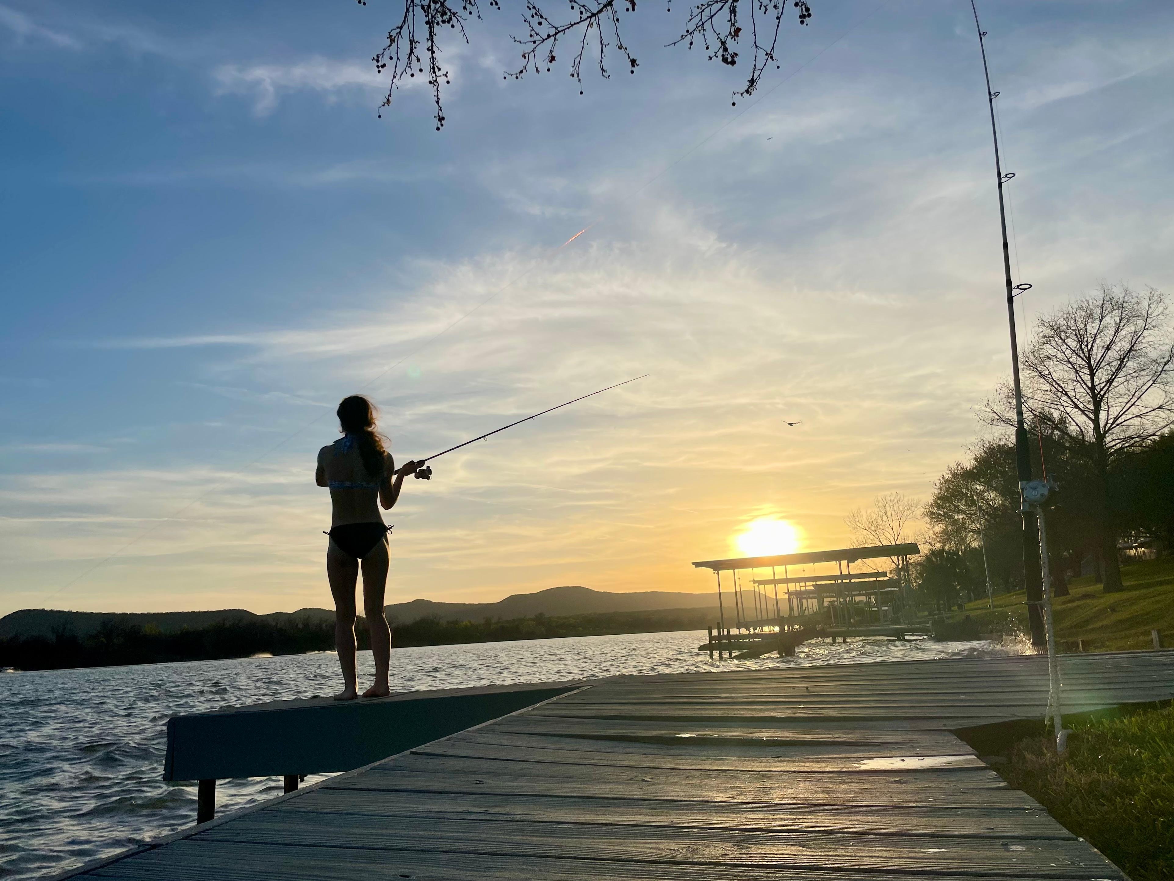 Fishing off the pier that extends from the boat dock. 