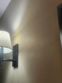 Shiny fingerprints on walls above the bed