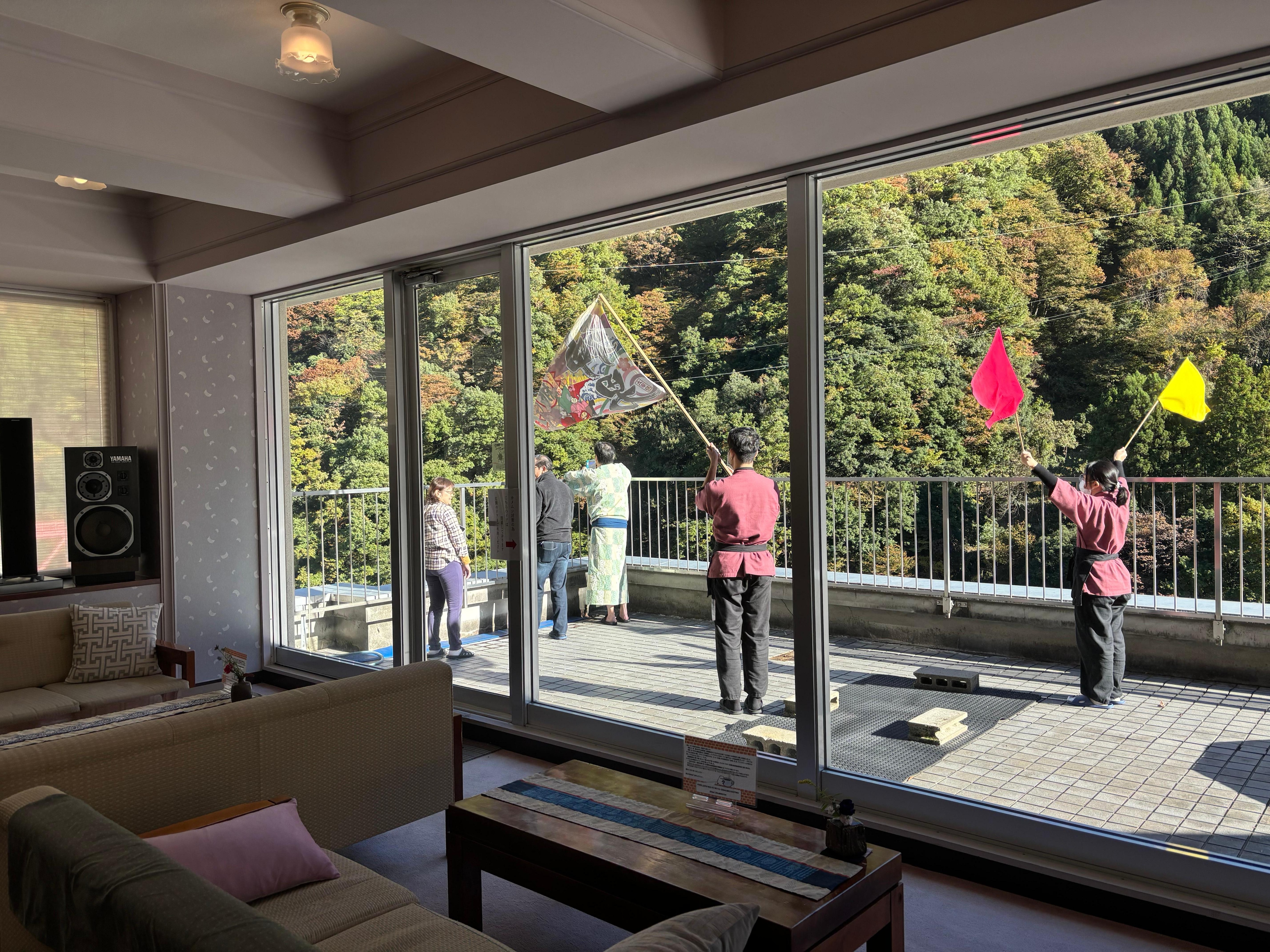 Staff waving to people on the Kurobe railway 