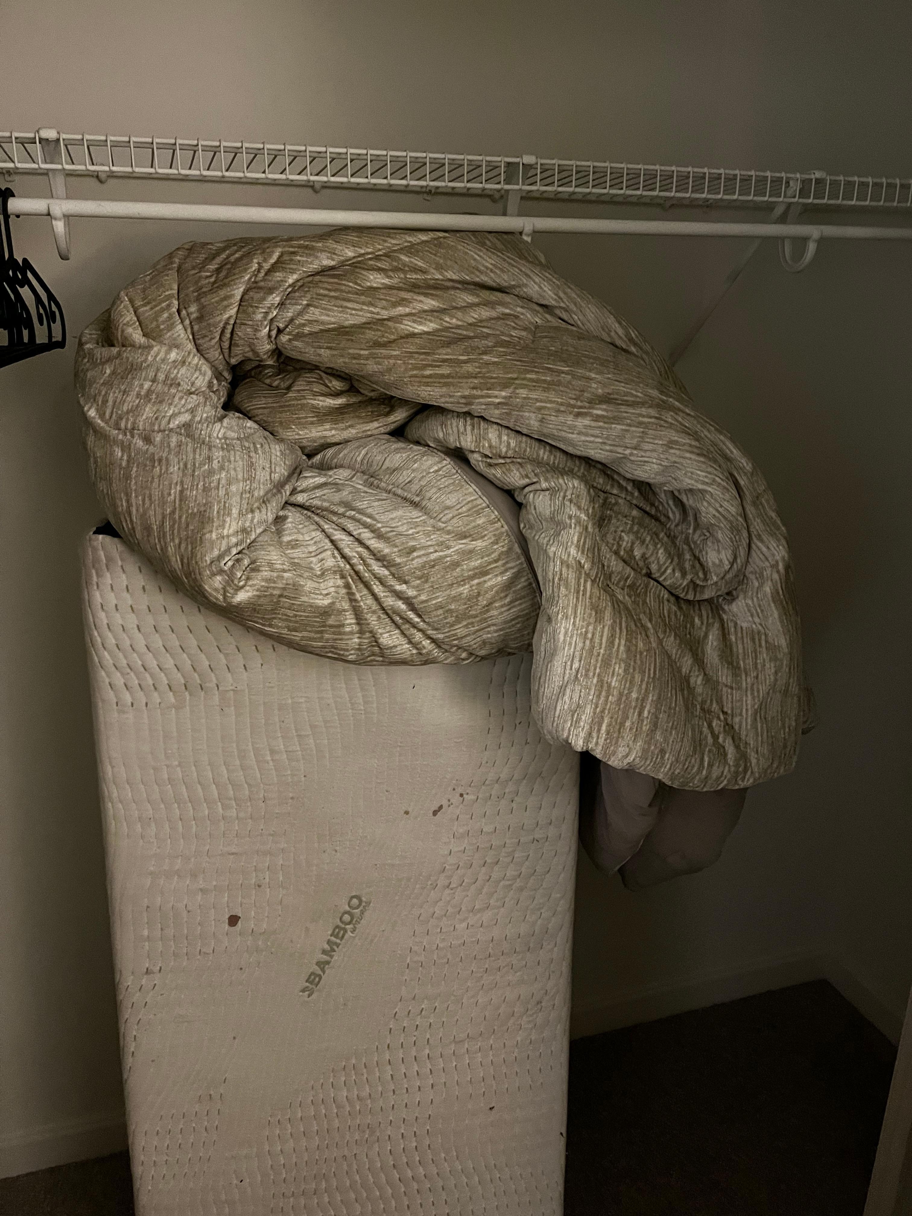 “extra bed” with dirty roll up mattress and dirty blankets on top 