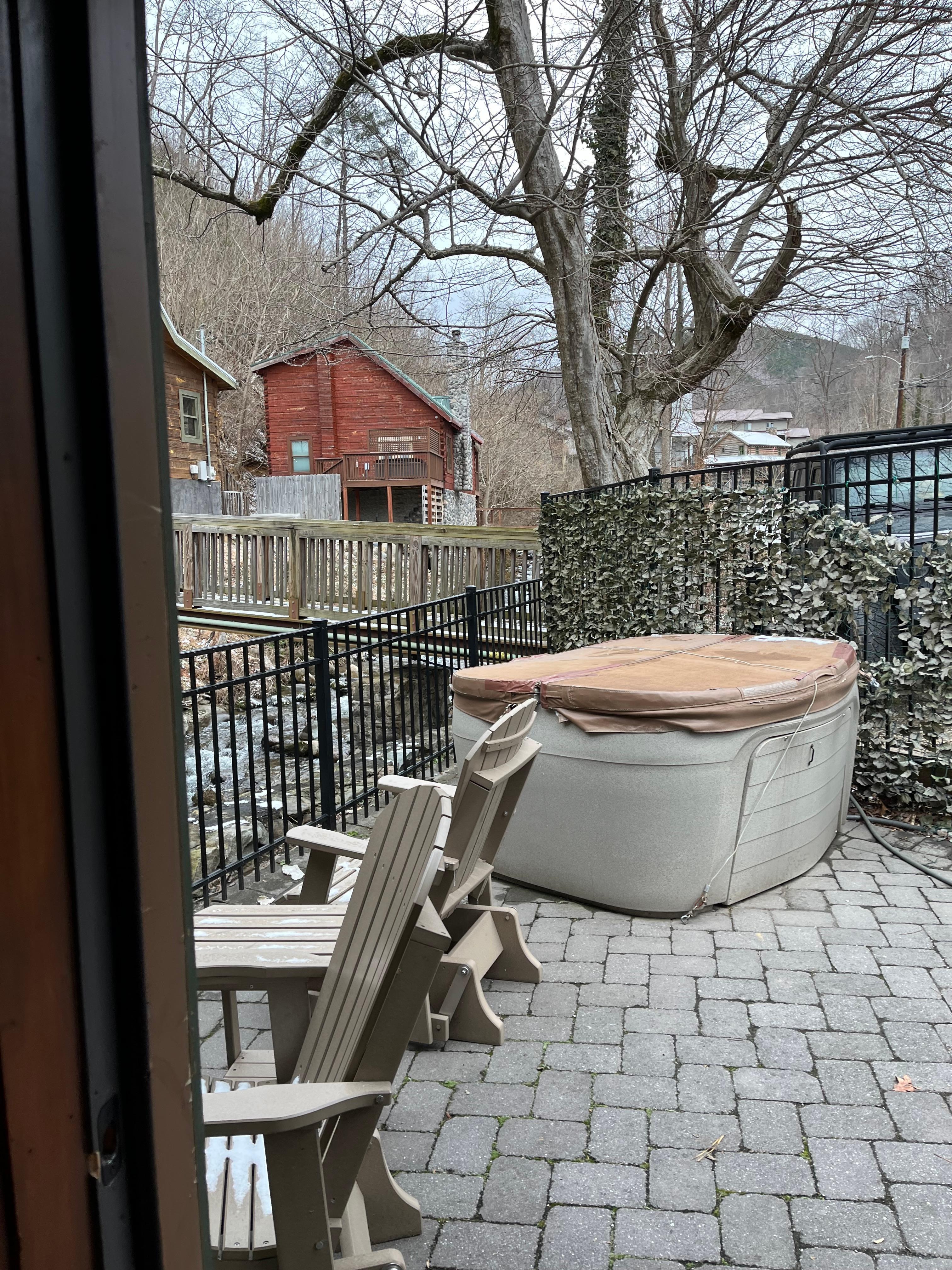 Delightful Patio Space with rocking chairs, table, and relaxing hot tub all overlooking the river!
