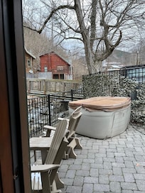 Delightful Patio Space with rocking chairs, table, and relaxing hot tub all overlooking the river!