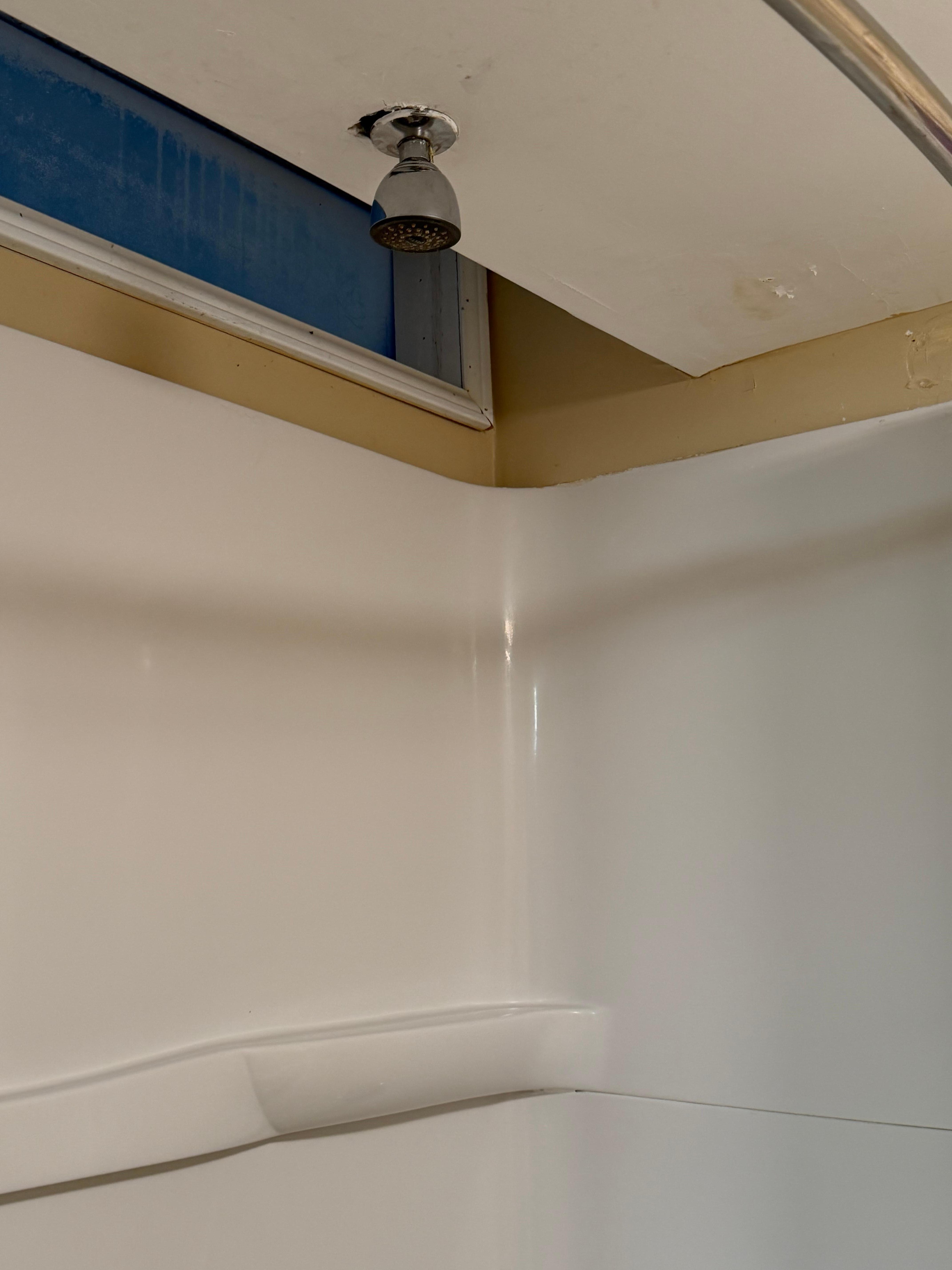 Shower head culked on the ceiling, very low pressure and the water wasn’t even hot