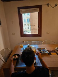 My 11-year old boy eating breakfast in the beautiful kitchen table watching out at the canal.