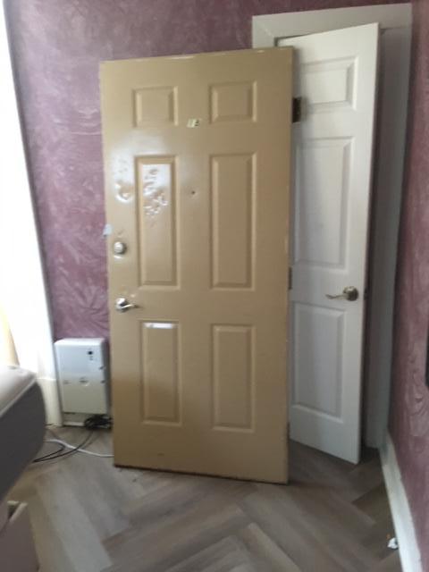 The unit's door, off its hinges and propped up in the bedroom.