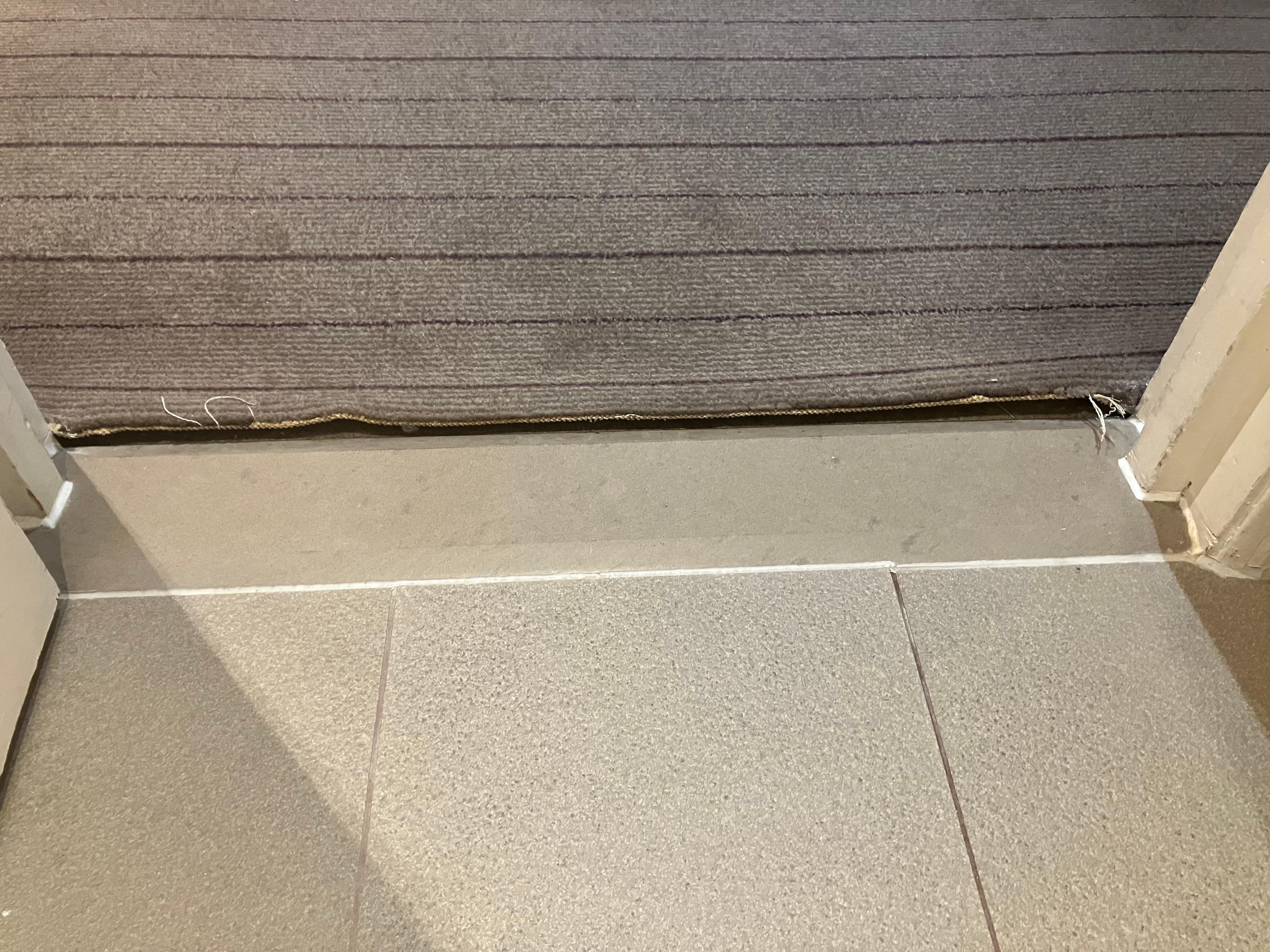 Loose, dirty carpet trip hazard.