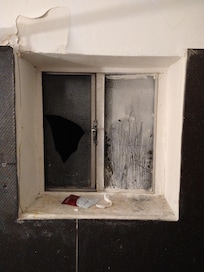 Broken window with leftover trash from the people stayed before me