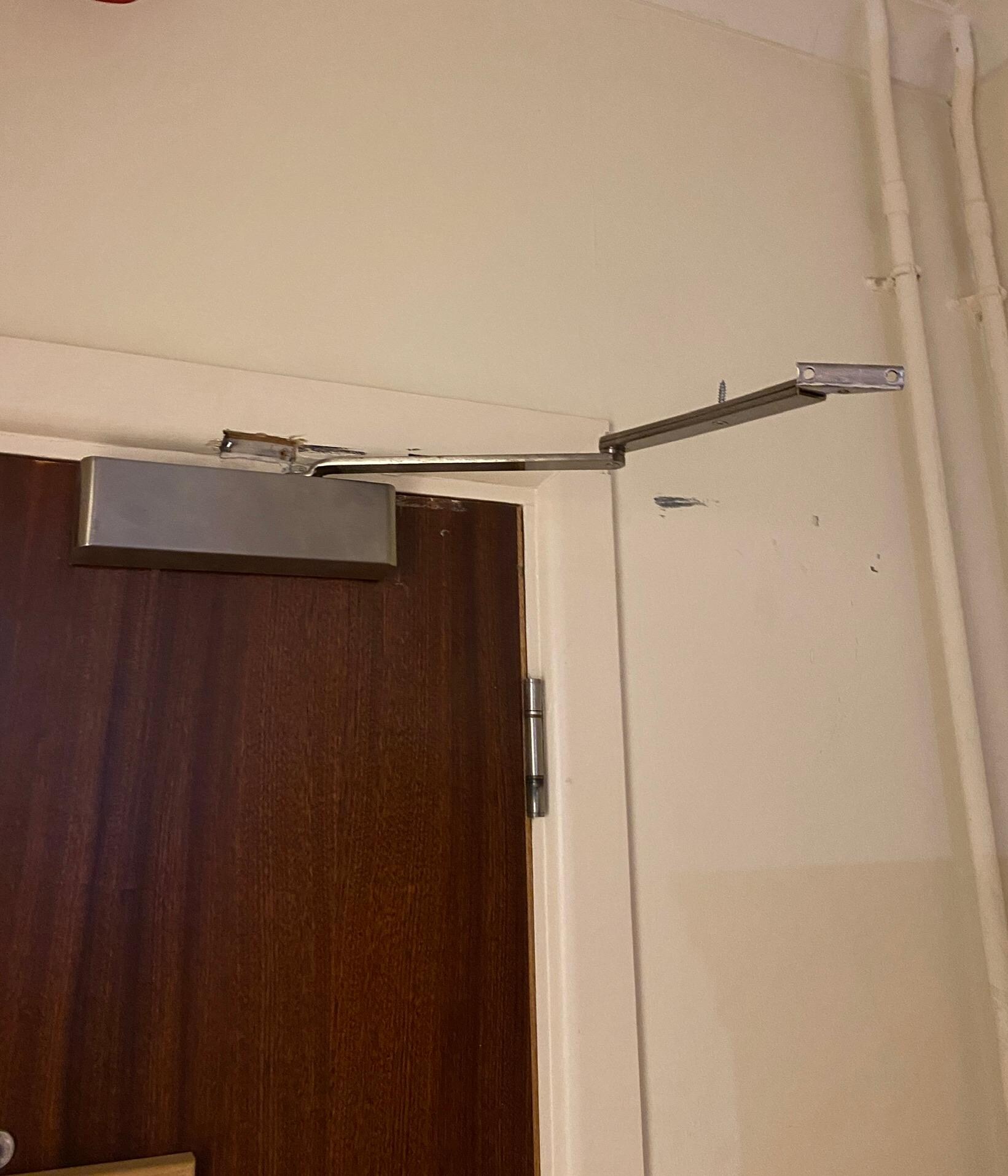 Door closer hanging off the wall. 