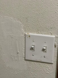 Dirt on light switch and poor wall patch