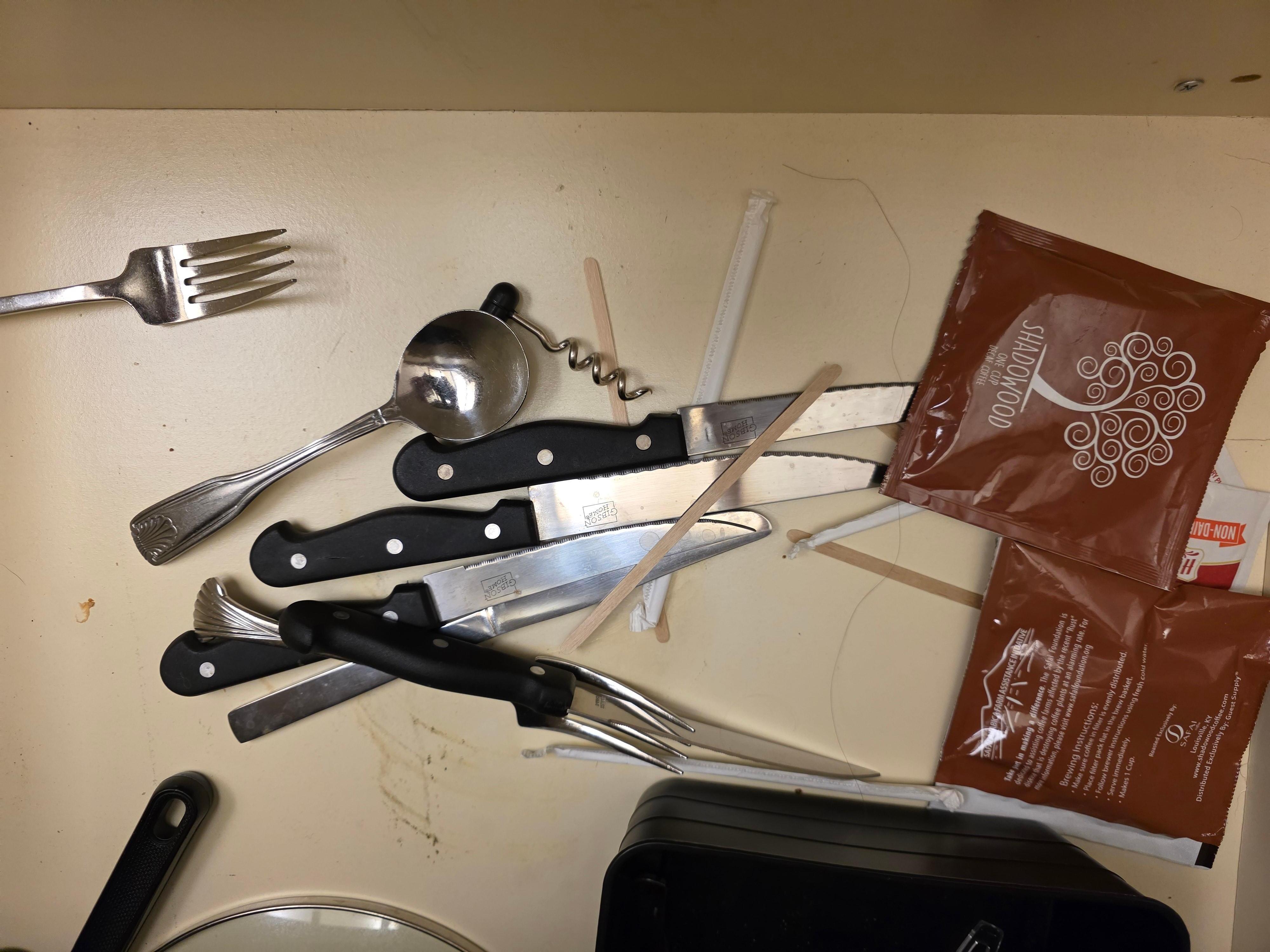 Nasty long hair mixed in with utensils in a dirty drawer