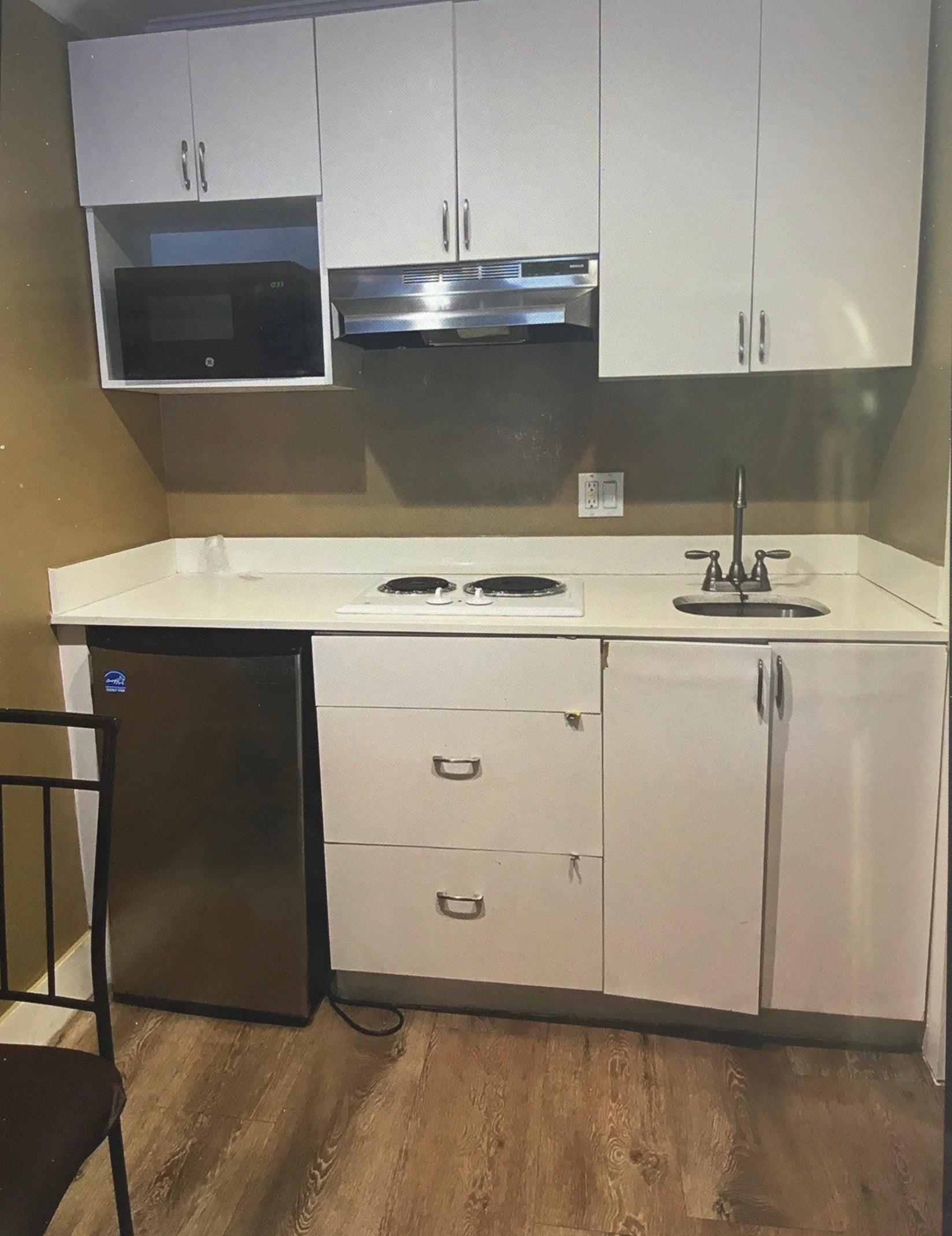 This is actual kitchenette. No coffee maker or cups, plates, silverware etc. cabinets donât close.