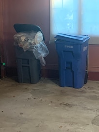 Garbage can overflowing from prior tenant.