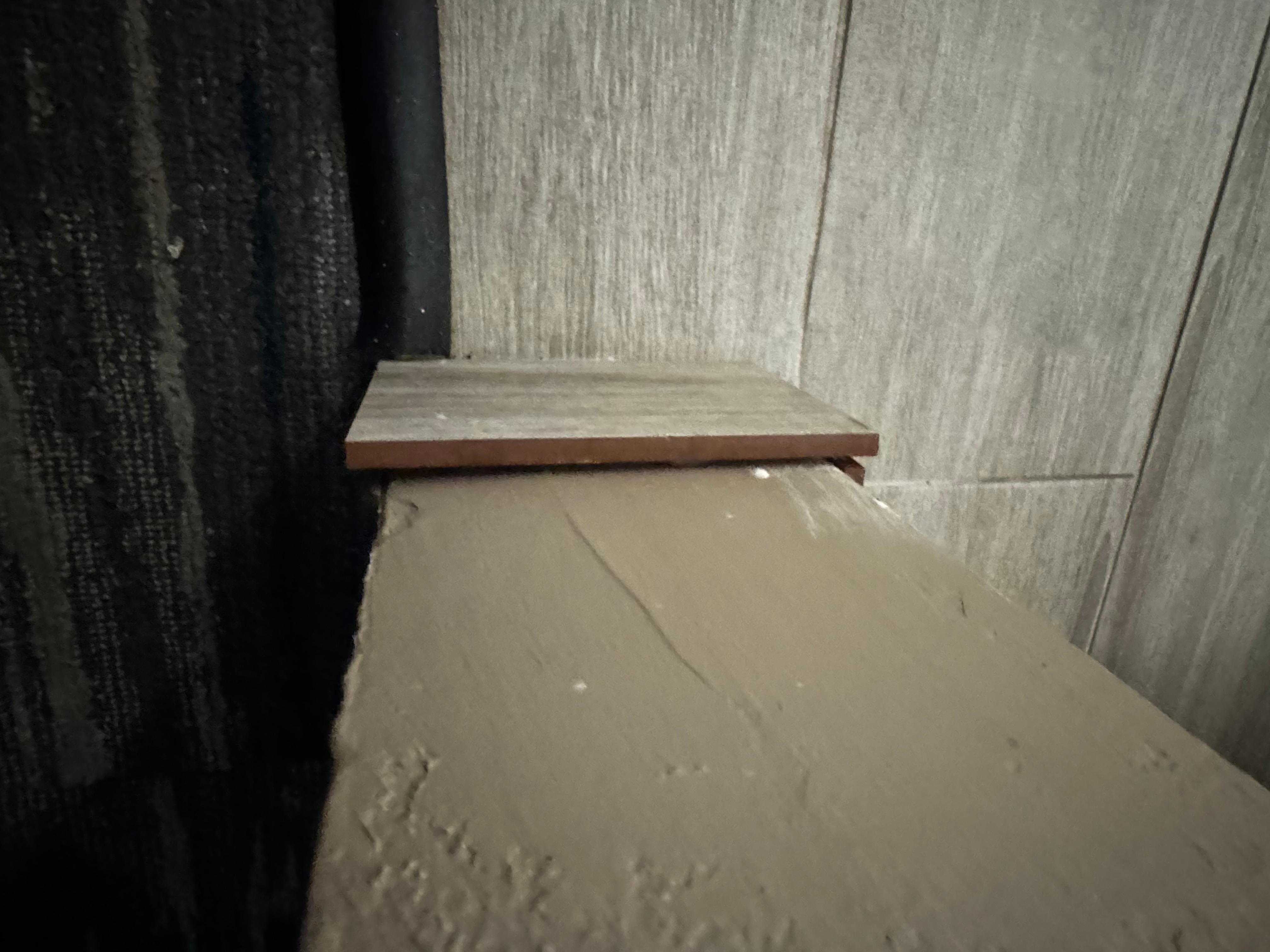 Random tile barely adhered to wall