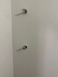 Towel holder in opposite wall of bathroom from shower and sink