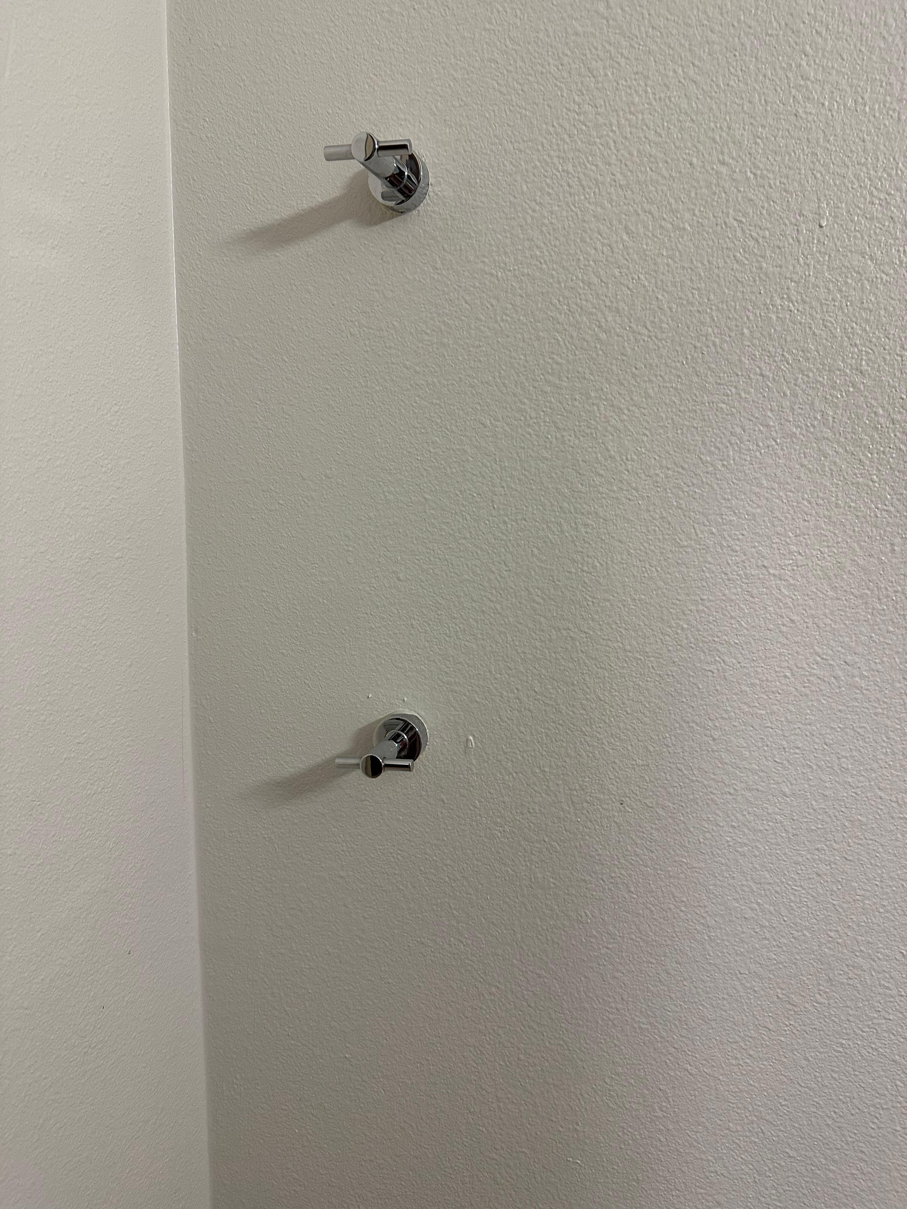 Towel holder in opposite wall of bathroom from shower and sink