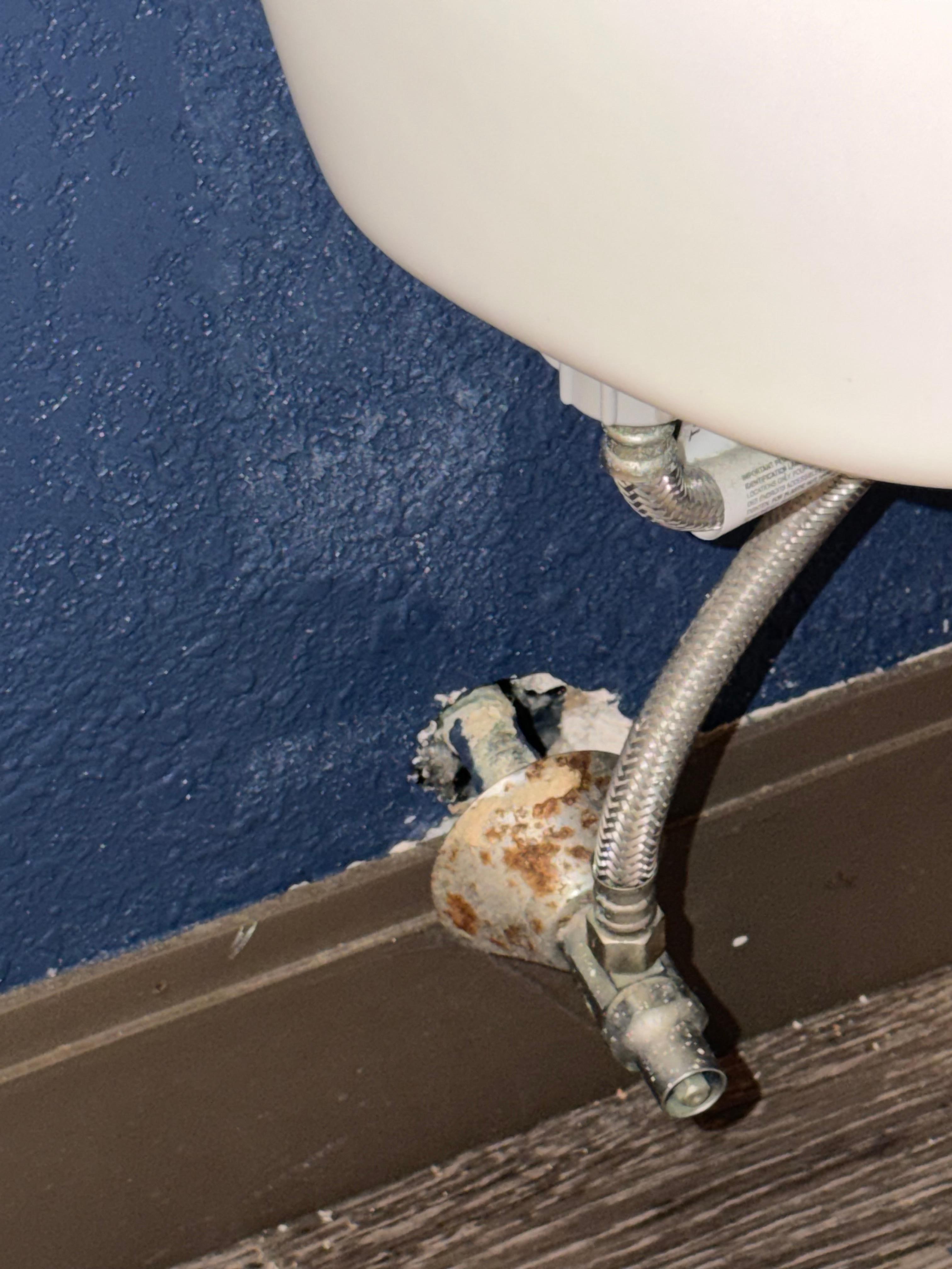 Large Hole in the wall behind the toilet. 