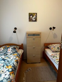 Schlafraum mit getrennten Betten. Ein zusätzlicher Kleiderschrank steht im Wohn- / Essraum