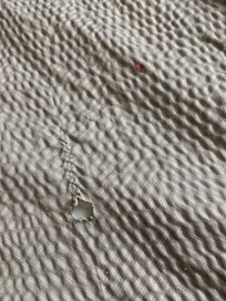 burn holes and red stains on bedding