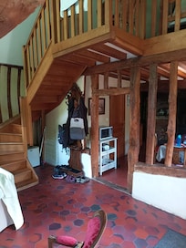 Treppenaufgang und Balken, die den EĂtisch vom Wohnbereich trennen.