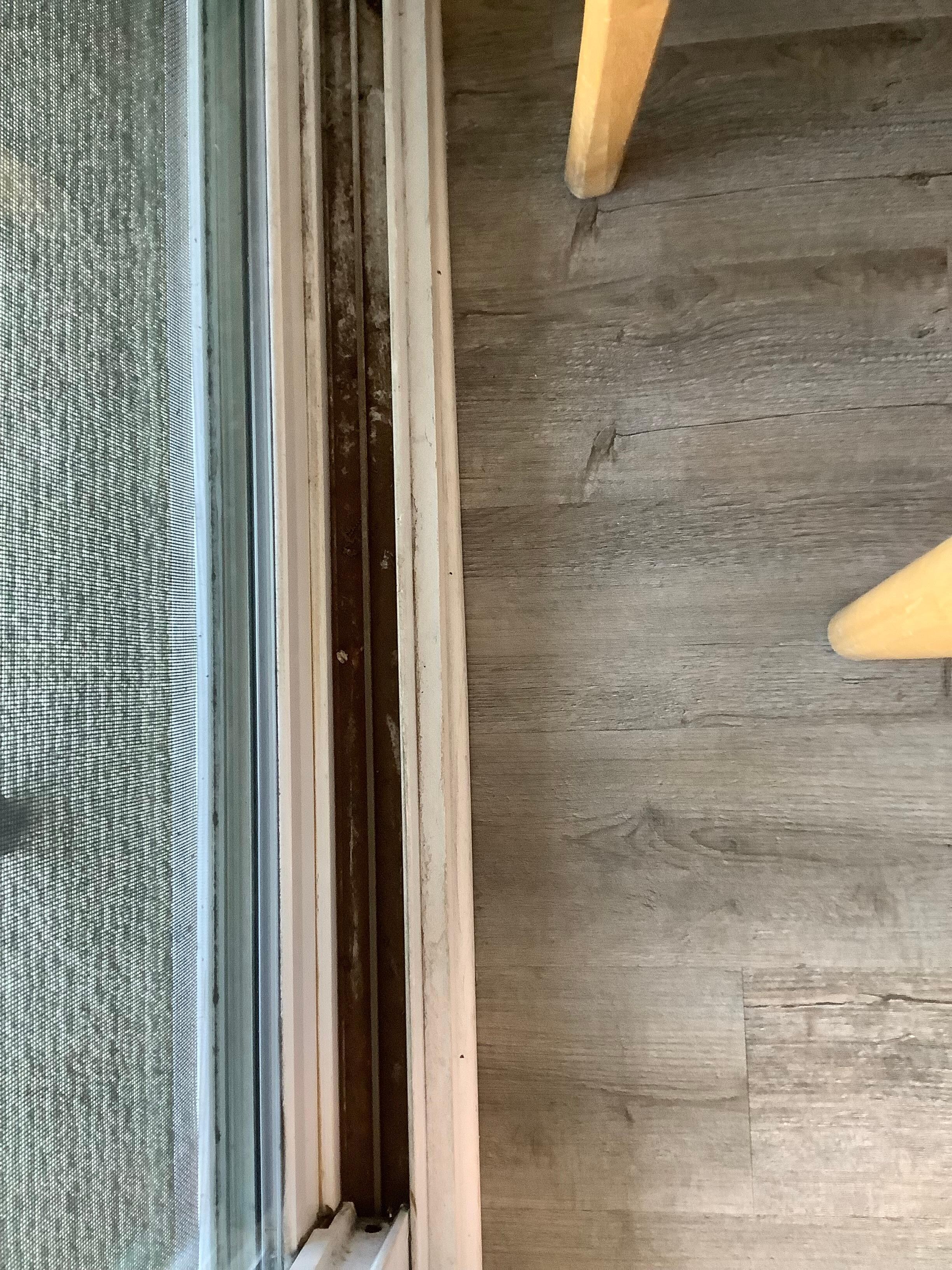 Caked  on  grime and dirt on both sides of sliding glass doors 