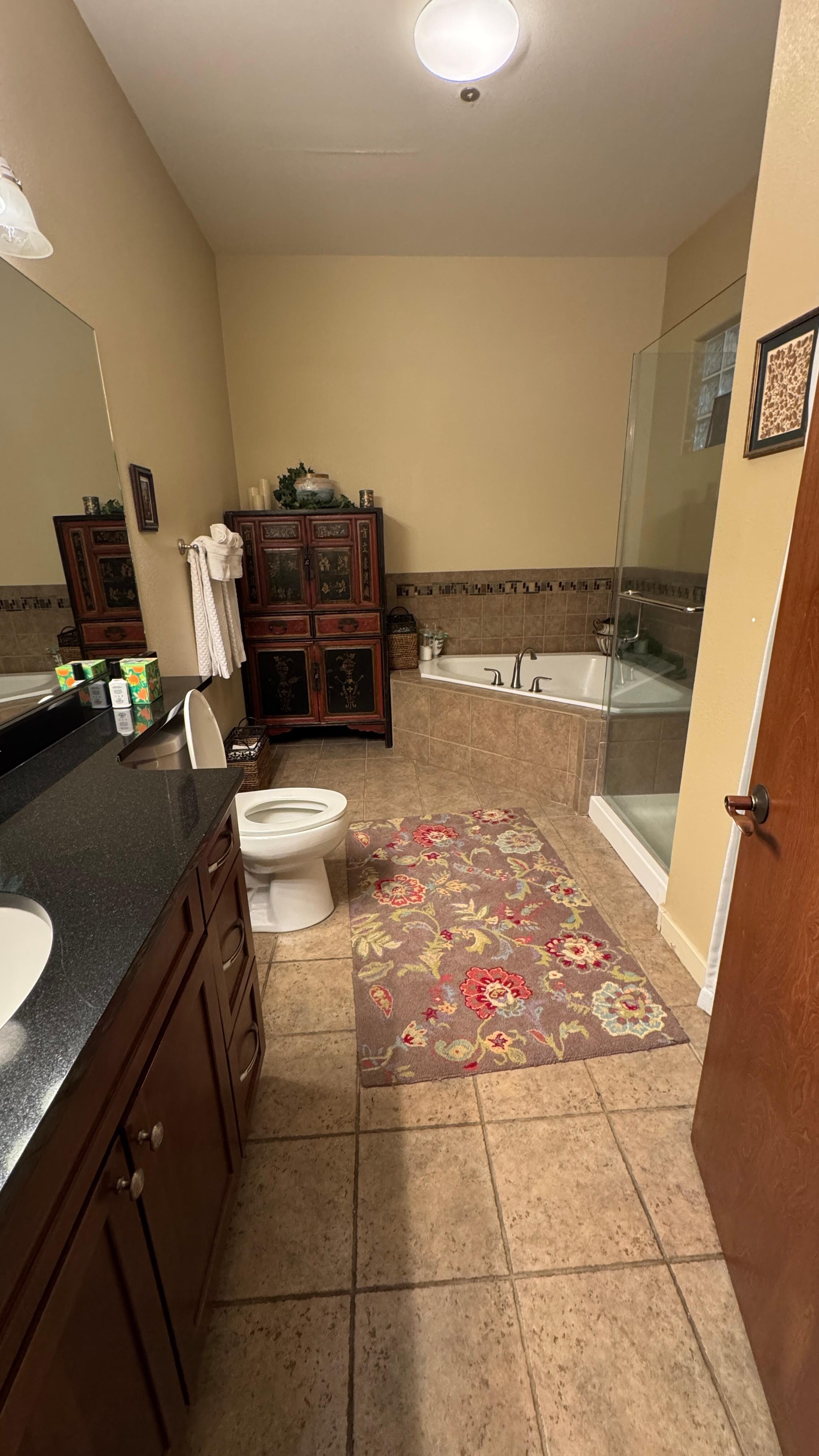 Bathroom, there is a stacked full-size washer and dryer behind the door to the right and the shower is kinda hard to see