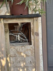 Unsafe electrics- many sockets and fittings hanging off wall