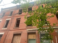 Abandoned building connected on the left, when facing front door. We watched raccoons and rodents exit from behind plywood covering lower windows.